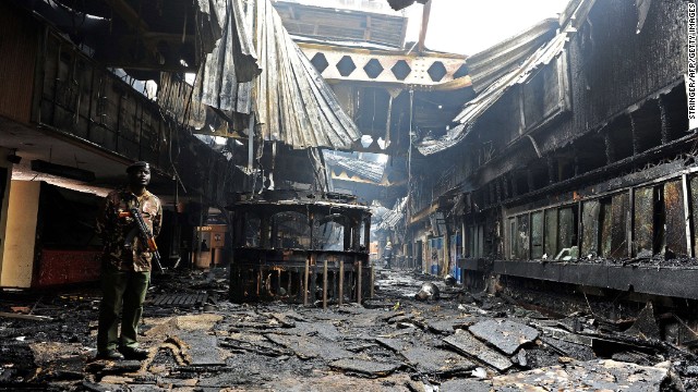 A soldier stands among the debris August 7. The cause of the fire is uknown, but security is being ramped up at the airport, an official said.