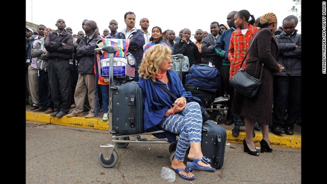 Stranded passengers wait outside the airport August 7.