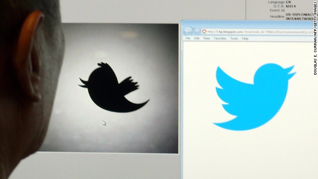 A man looks at a computer monitor showing the old and new Twitter logos. The social networking company dropped the name and now uses the bird image alone.