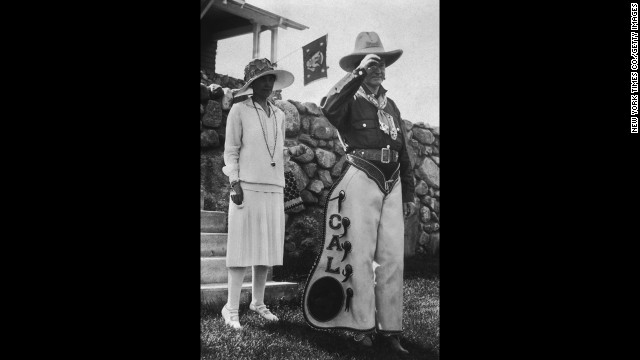 President Calvin Coolidge poses in his personalized chaps with first lady Grace Coolidge at a party celebrating the Fourth of July and his 55th birthday at the Summer White House in South Dakota, 1927.