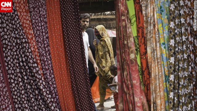 Shoppers make their way past beautiful fabrics and other items on display at Minab's weekly open-air market. See more photos on <a href='http://ireport.cnn.com/docs/DOC-969913'>CNN iReport</a>.
