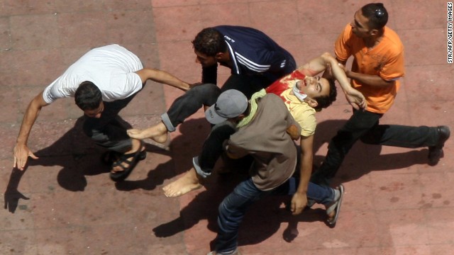 Morsy supporters carry a wounded man during clashes with riot police in Cairo on August 14.