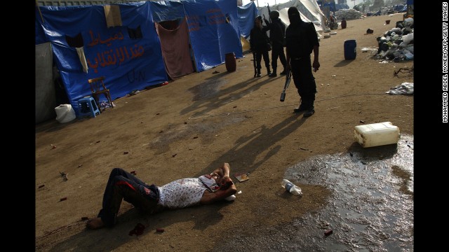Riot police stand behind a wounded man near Rabaa al-Adawiya mosque in Cairo on August 14.