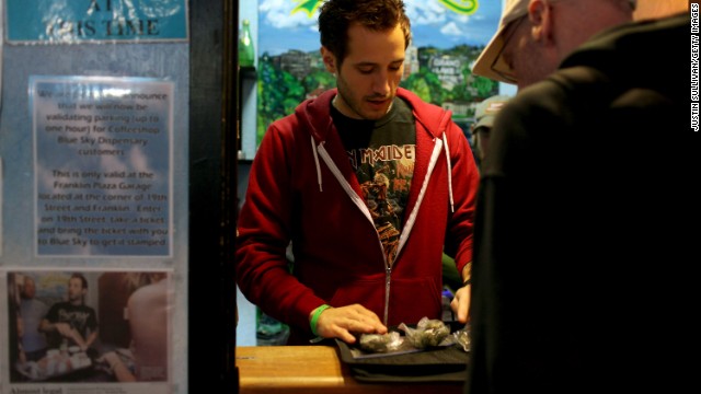 Coffeeshop Blue Sky worker Jon Sarro, left, shows a customer different strains of medical marijuana on July 22, 2009, in Oakland, California. Voters in the city approved a measure during a vote-by-mail special election for a new tax on sales of medicinal marijuana at cannabis dispensaries.