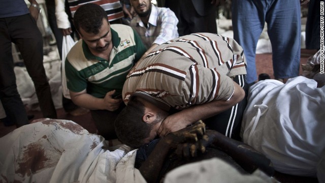 Egyptians mourn over a body wrapped in shrouds at a Cairo mosque August 15.