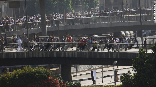 Morsy supporters march in Cairo. Gunfire was heard from the overpass as tear gas was fired.