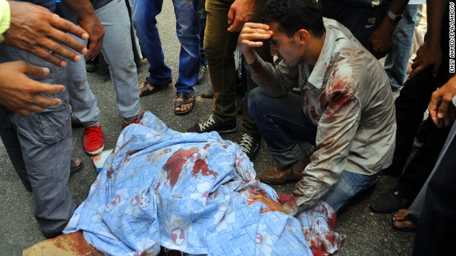 A group of men gather around an injured protester in Giza on August 16.