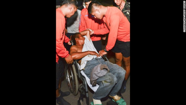 A survivor in a wheelchair is assisted as he arrives at the hospital on August 17. 