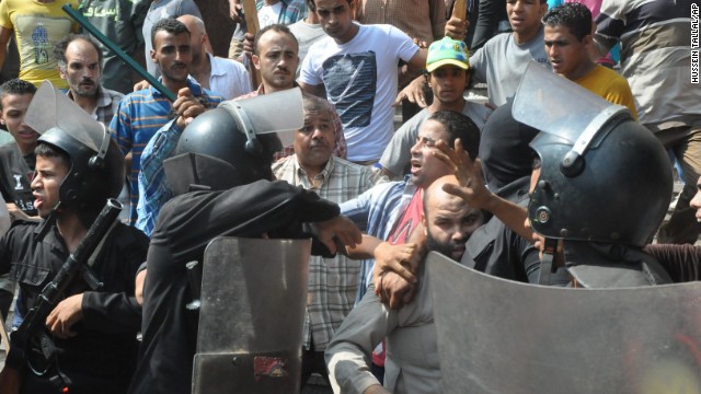 Egyptians security forces escort a supporter of the Muslim Brotherhood out of the Al-Fateh mosque and through an angry crowd in Ramses Square on August 17.