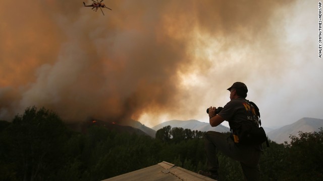John Koth climbs to the roof of a neighbor's house near Hailey to photograph the blaze on August 16. 