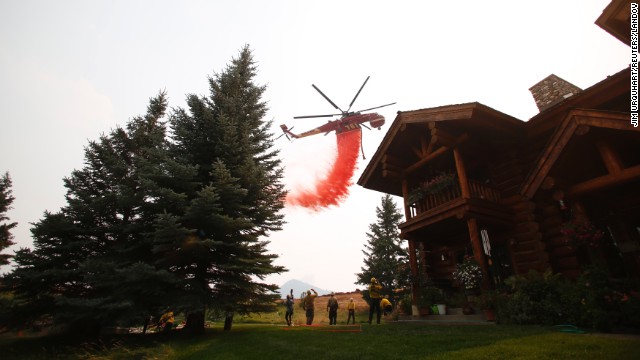 A helicopter drops fire retardant to protect homes outside Ketchum, Idaho, from the Beaver Creek Fire on Sunday, August 18. The fire has forced the evacuation of several neighborhoods.