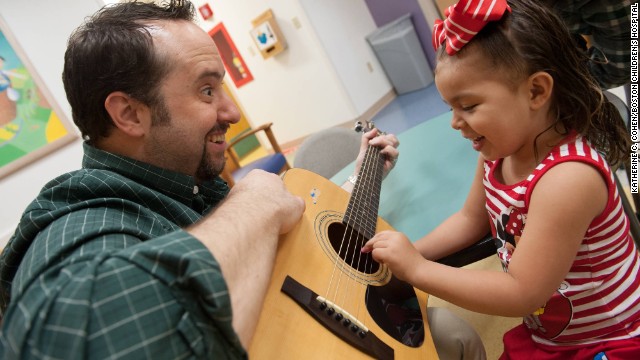 Brian Jantz, a music therapist at Boston Children's Hospital, plays with a patient, Yaneishka Trujillo. Jantz uses music to engage with children.