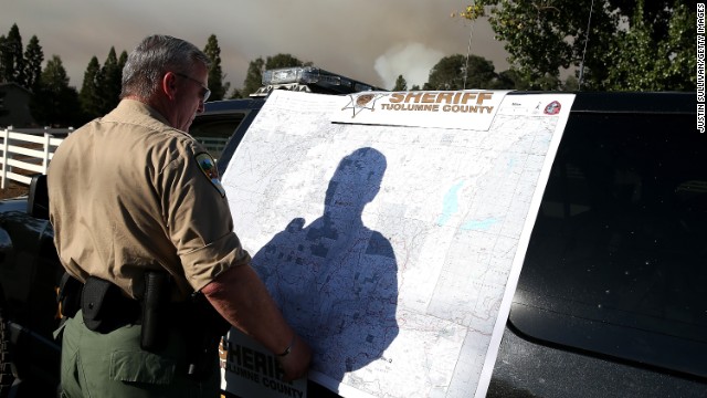A Tuolumne County sheriff's deputy looks at an incident map of the Rim Fire on August 22, in Groveland, California.