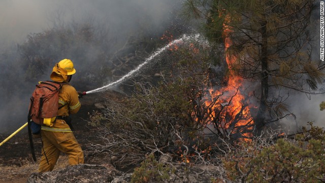 A firefighter douses a spot fire, as he battles the Rim Fire near Yosemite National Park in California. 