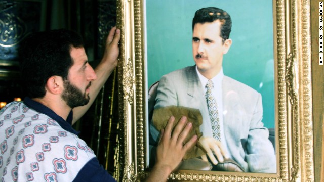A shopkeeper cleans a portrait of al-Assad in Damascus on June 20, 2000, as the ruling Baath Party prepared to wind up its historic congress by consecrating al-Assad as its secretary-general and choosing a new leadership body.