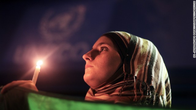 A young woman holds a Syrian revolution flag and a candle during a protest of President Bashar al-Assad in front of the U.N. headquarters in Gaza City on Friday, August 23. U.N. Secretary-General Ban Ki-moon intends to conduct a "thorough, impartial and prompt investigation" into the alleged chemical weapons attack in Syria.