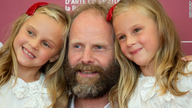 Twins Pia Keelman, left, and Chiara Keelman pose at the festival with director Philip Groning for the film "The Police Officer's Wife" on August 30.