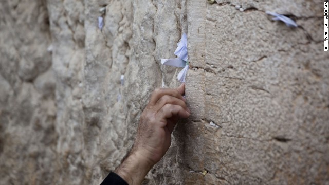 A man sticks a note into the Western Wall. This is the last structure remaining from the Jewish Temple, destroyed by the Romans, in the Old City.