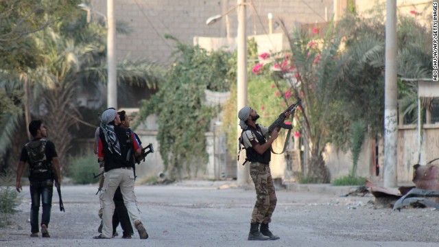 A rebel fighter points his weapon at Syrian regime forces in Deir ez-Zor on September 2.