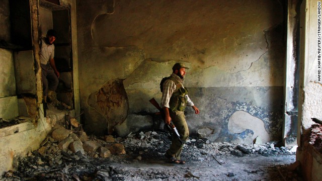 Free Syrian Army fighters walk inside a damaged house in Aleppo on September 3.