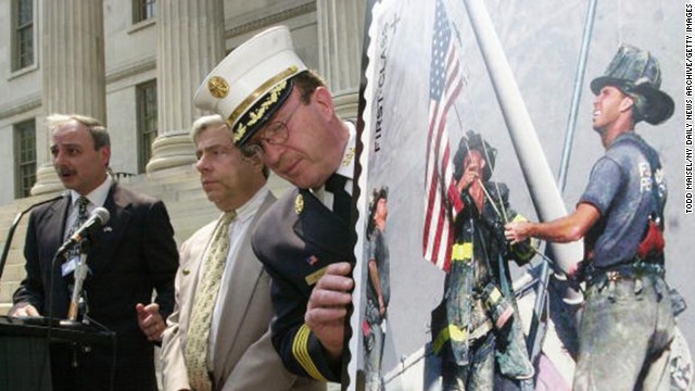 The stamp is displayed at a ceremony outside of the Brooklyn Borough Hall in New York on July 2, 2002. From left, Brooklyn Postmaster Joseph Lubrano, Borough President Marty Markowitz and Harold Meyers of the New York City Fire Department were in attendance.