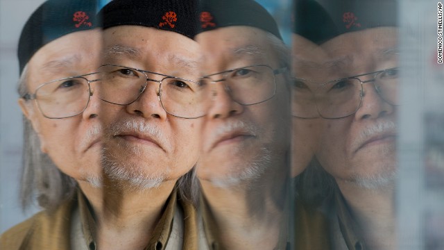 Manga artist Leiji Matsumoto is reflected on glass panels as he poses for portraits on September 3.