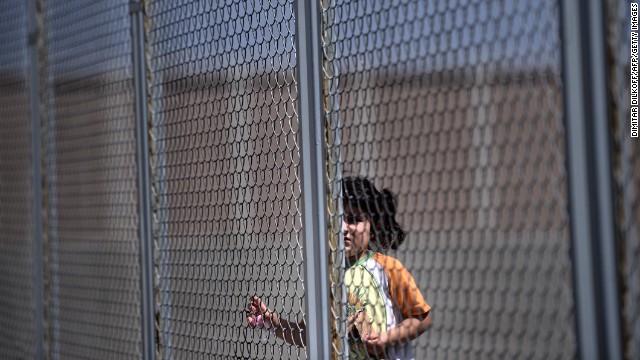 A Syrian girl stands behind a fence at Bulgaria's shelter near Lyubimets on August 28. More than 3,100 immigrants -- half of them Syrians -- have crossed into Bulgaria from neighboring Turkey this year, doubling their numbers compared with 2012 and and causing Bulgaria's few temporary accommodation facilities to overflow. 