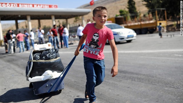 A child pulls a suitcase as Syrian refugees arrive at the Cilvegozu crossing gate of Reyhanli in Turkey's Hatay province on Saturday, August 31.