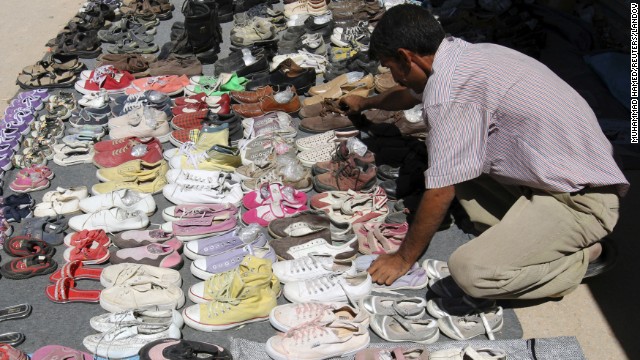 A Syrian refugee displays second-hand shoes for sale at the main market at the Zaatari Refugee Camp close to the Jordanian city of Mafraq, near the border with Syria, on September 8. 