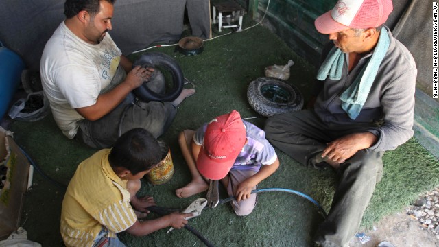 Syrian refugee workers fix cart wheels at their shop at the Zaatari Refugee Camp on September 8. Jordan has 515,000 registered Syrian refugees.