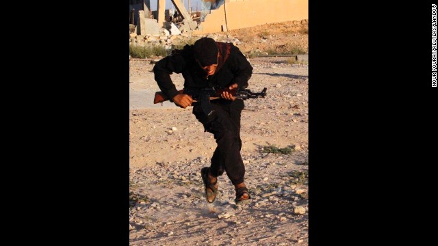 A Free Syrian Army fighter runs for cover in Raqqa province on September 8.