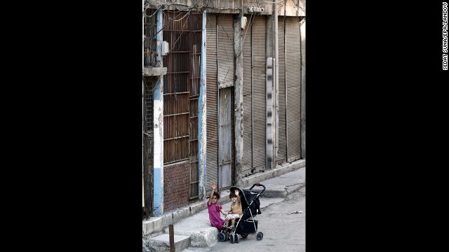 Two Syrian refugee children sit outside a house where they currently live in Istanbul on September 9.