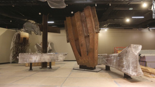 The "Cross," made of intersecting steel beams found in the rubble of 6 World Trade Center, and a fragment of a trident column, center, one of 84 that formed the exterior structure of each tower, are prepared for display. 