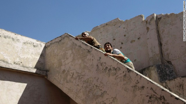 Free Syrian Army fighters climb a flight of stairs to take positions near the Hanano barracks on September 11.