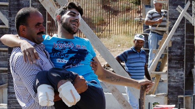 Mustafa Abu Bekir, who was wounded while fighting with the Free Syrian Army, smiles as he meets relatives after crossing the Cilvegozu gate border in Turkey's Hatay province on Monday, September 9.