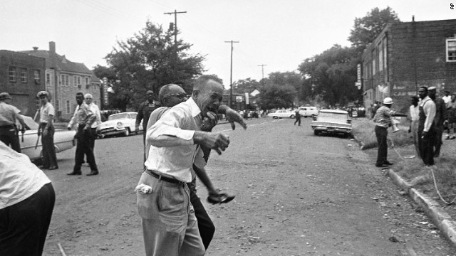 A grieving relative is led away from the site of the 16th Street Baptist Church bombing in Birmingham, Alabama, on September 15, 1963. Four black girls were killed and at least 14 others were injured, sparking riots and a national outcry.