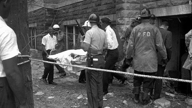 Firefighters and ambulance attendants remove a body from the church.