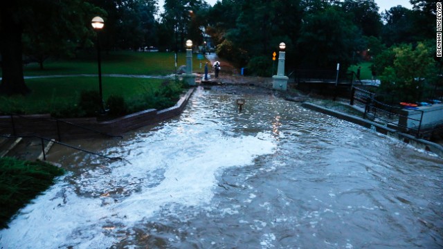 Flash flood waters rush over a walking path in downtown Boulder on September 12.