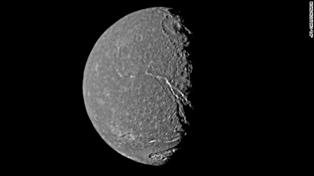 Uranus' moon Titania shows a crater-pocked surface as well as prominent fault valleys that stretch across the moon.