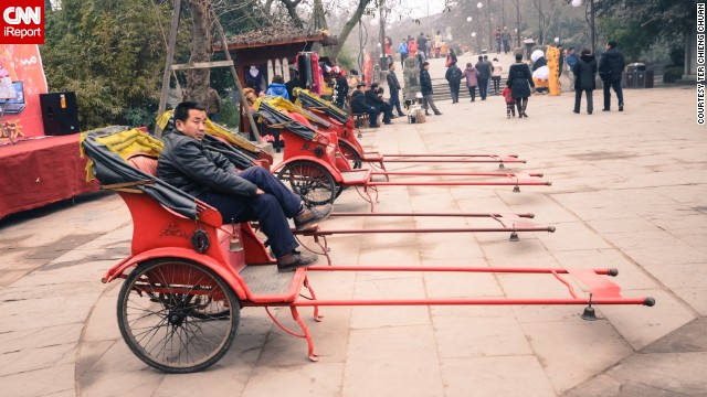 A <a href='http://ireport.cnn.com/docs/DOC-919419'>rickshaw driver</a> relaxes while awaiting customers in this popular tourist town near Chengdu.