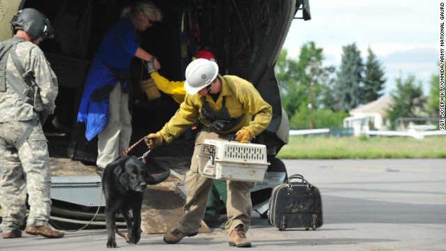 Guardsmen help residents and their pets off a Colorado National Guard Chinook helicopter at the Bolder Municipal Airport in Boulder, Colorado, on September 13. 