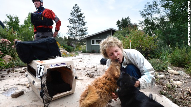 Suzanne Sophocles hugs her dogs after they were rescued from her flooded home on September 13 in Boulder. Thousands of people stranded by the flood waters in Colorado were finally able to come down by trucks and helicopters, two days after seemingly endless rain turned normally scenic rivers and creeks into coffee-colored rapids that wrecked scores of roads and wiped out neighborhoods. 