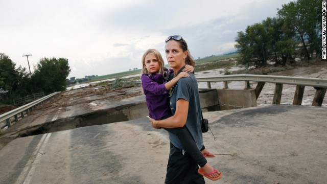 Samantha Kinzig of Longmont, Colorado, and her 5-year-old daughter Isabel take a closer look at the damaged bridge on Weld County Road 1 on September 13.