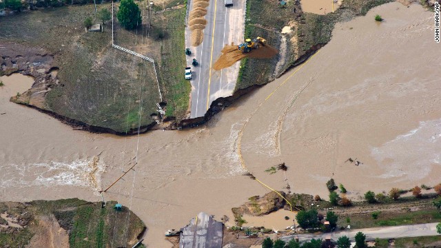 A road crew works on a stretch of highway washed away by flooding along the South Platte River near Greeley, Colorado, on Saturday, September 14.