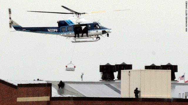 A police helicopter hovers above snipers on the roof of a building at the Washington Navy Yard.