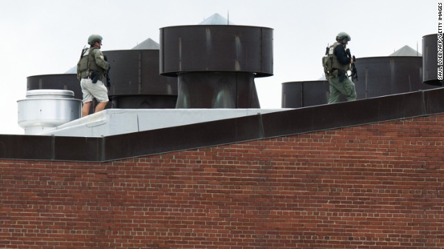 Police officers walk on a rooftop at the Washington Navy Yard.