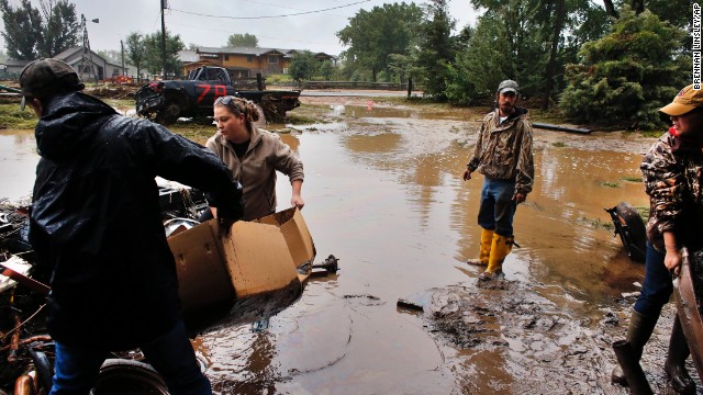 Local residents, from left, Levi Wolfe, Miranda Woodard, Tyler Sadar, and Genevieve Marquez help salvage and clean property after days of flooding in Hygeine, Colorado, on September 16.