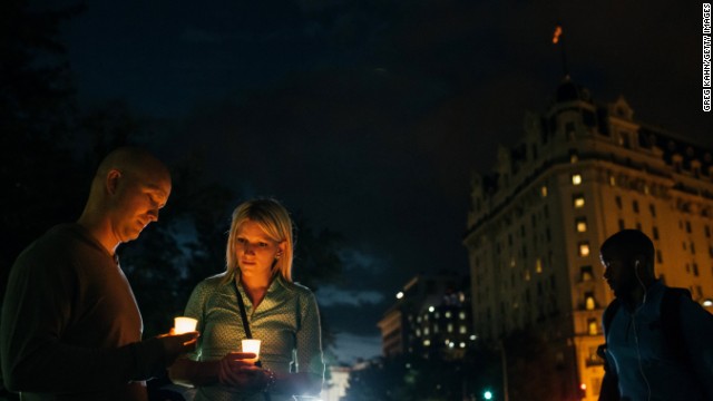 Dave Gray and his wife, Brittany, of Salt Lake City hold candles in remembrance of people affected by gun violence.
