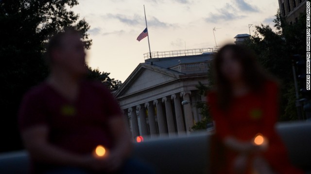 The U.S. flag above the Treasury Department flies at half-staff.