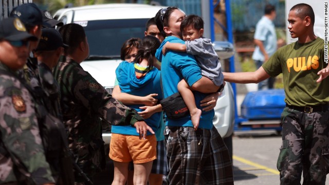 A two-year-old boy is carried by his father after a rescue mission by state security forces from Muslim rebels following an assault on September 17.